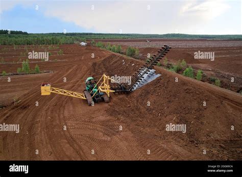 Peat extraction site. Harvester at collecting peat on peatlands. Mining and harvesting peatland ...