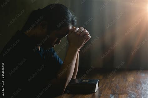 Prayer person hand in black background. Christian catholic woman are praying to god in dark at ...