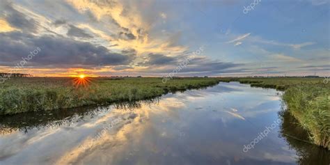 Sunset over river in marshland nature reserve — Stock Photo © CreativeNature #157406512