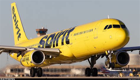 a large yellow jetliner taking off from an airport runway with it's ...