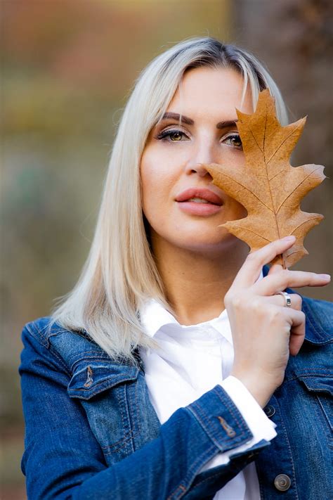 5K free download | woman in blue denim jacket holding brown maple leaf, HD phone wallpaper | Peakpx