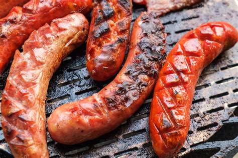 Grilling sausages on barbecue grill Stock Photo by ©kavita 84731754