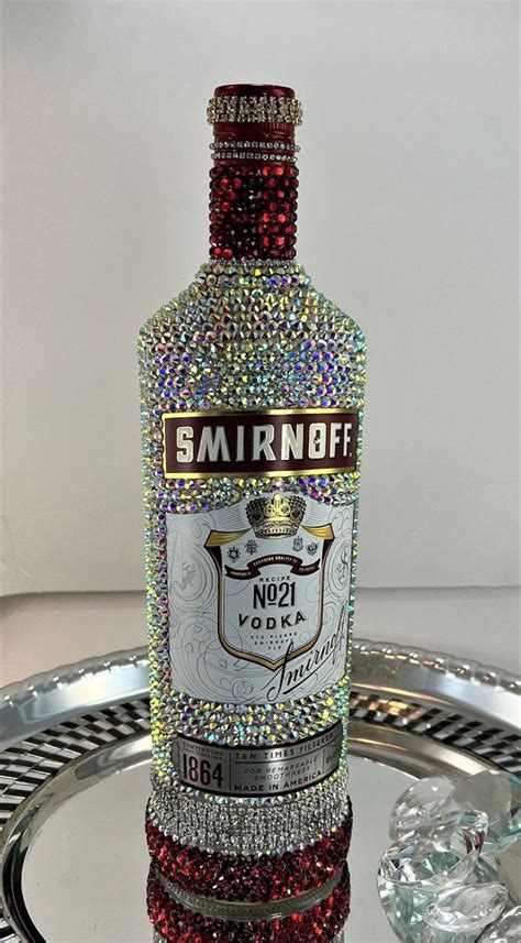 a bottle of smirnobff vodka on a tray with some crystal stones around it