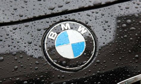 The BMW logo on a black car with raindrops Wallpaper Download 800x480