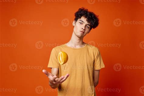 guy with curly hair oranges in hands fruit red background 21986707 ...