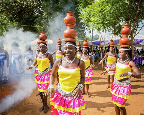 Women wearing brightly coloured traditional clothing walk and carry ...