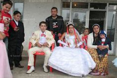 A young married roma (gypsy) couple sit with the bride's parents, in Sintesti, Romania, on ...