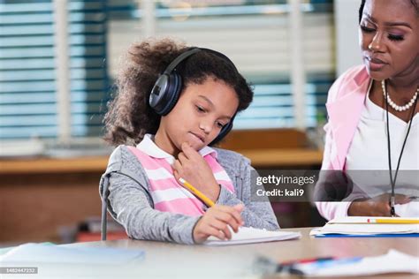 Teacher Helps Student Wearing Noisecancelling Headphones High-Res Stock Photo - Getty Images