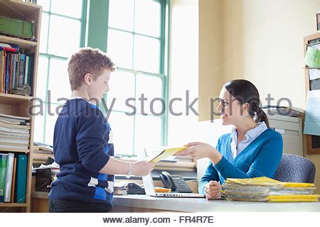 student handing in homework to teacher Stock Photo: 100295228 - Alamy