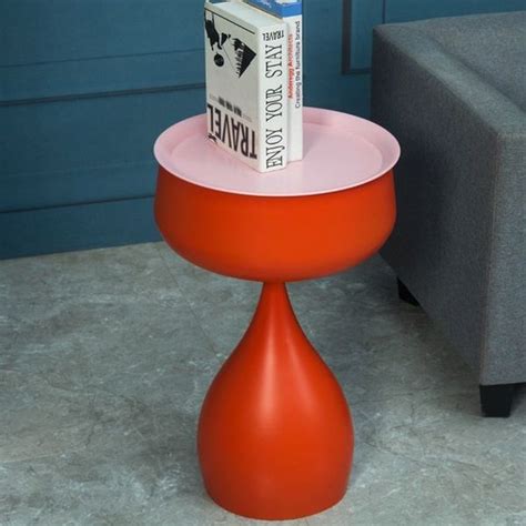 an orange table with books on it and a gray couch in the backround