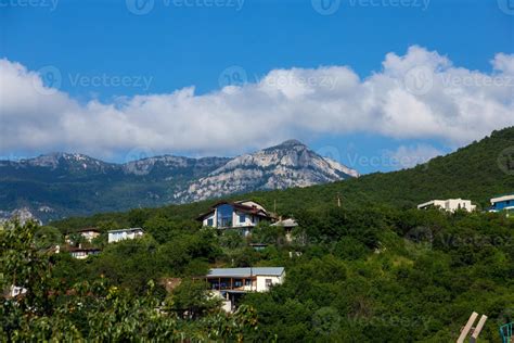 Houses in a mountain valley against a blue sky. 8809962 Stock Photo at Vecteezy