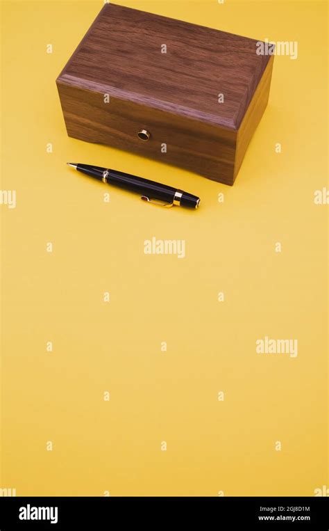 black lacquer luxury pen and wooden box on a yellow background Stock Photo - Alamy