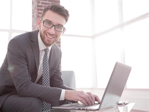 Premium Photo | Young businessman using laptop and smiling