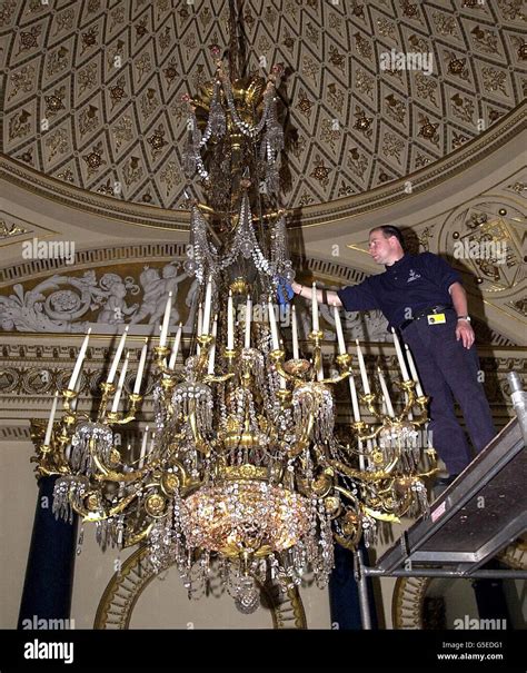 Technician Mark Boyd cleans the largest chandelier in the Music Room, Buckingham Palace, London ...