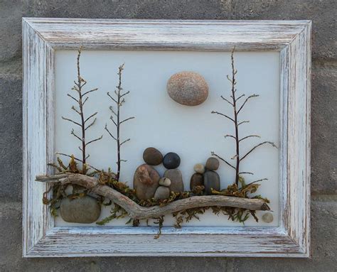 Pebble Art (Pebble Family of Five or Pebble Friends sitting on a log under trees and sun) in a ...