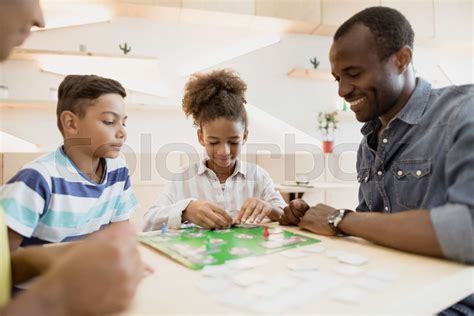 african-american family playing board game in cafe | Stock image | Colourbox