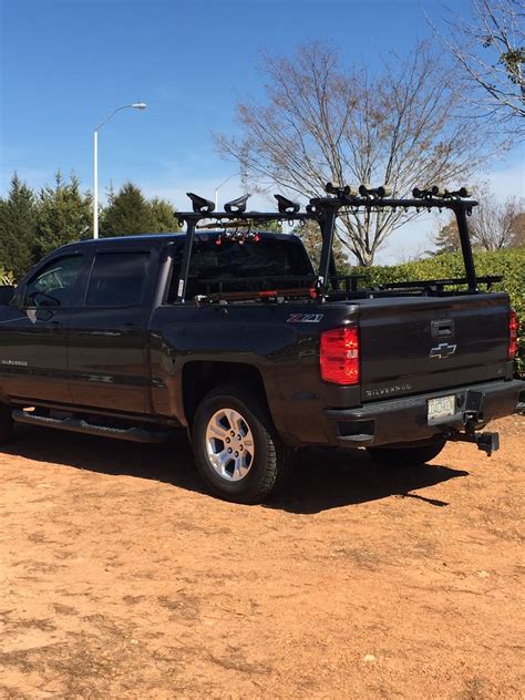 the truck is parked in the dirt with its bike rack on it's back