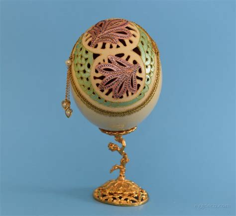 an ornately decorated egg on a stand against a blue background