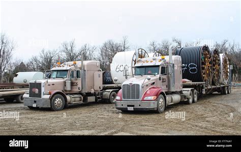 Two American Peterbilt 379 semi trucks hauling reels of HDPE plastic ...