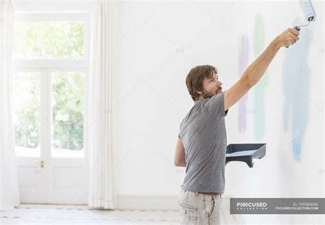 Man painting wall in living space — choosing, achievement - Stock Photo | #199384696