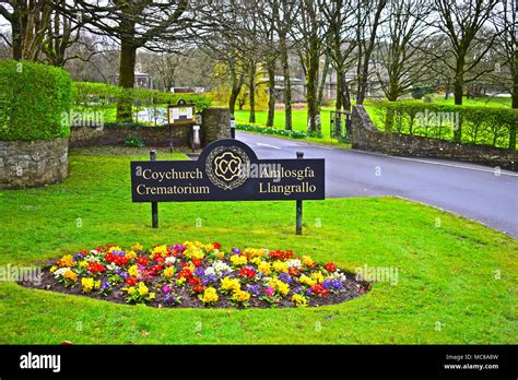 Beautiful & colourful border flowers in front of the bilingual sign for Coychurch Crematorium ...