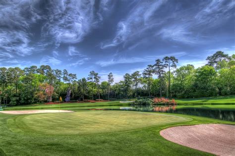 Download A scenic golf course surrounded by trees. Wallpaper ...