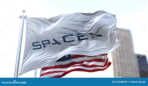 White Flag with the SpaceX Logo Flapping in the Wind with the American Stars and Stripes Flag in ...