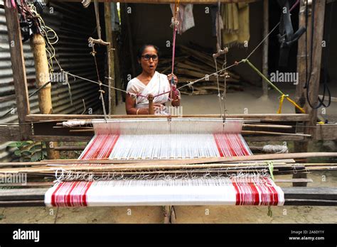 Village woman with domestic handloom, weaving a traditional Assamese ...