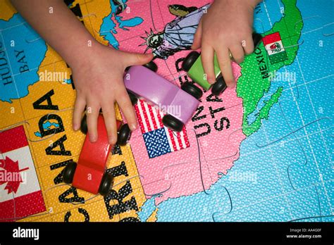 Kids hands playing with wooden cars on largw world map puzzle Stock Photo - Alamy
