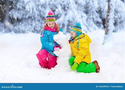 Kids Making Winter Snowman. Children Play in Snow Stock Photo - Image ...