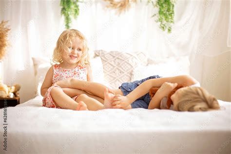 Cute sweet toddler children, tickling feet on the bed, laughing and ...