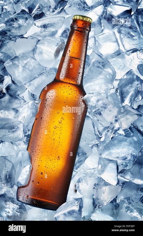 Cold bottle of beer in the ice cubes. There is condensed moisture over glass Stock Photo - Alamy