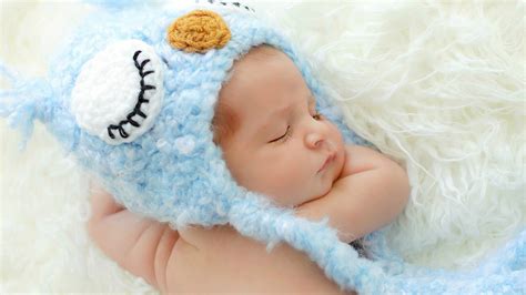 Cute Newborn Baby Is Sleeping On White Woolen Bed Wearing Knitted ...