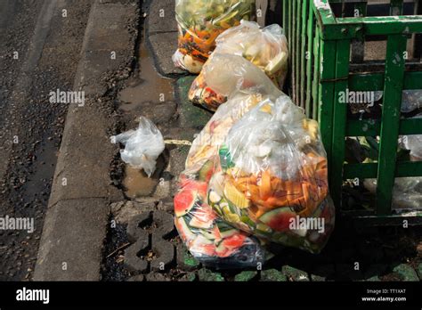 Food waste in plastic bags on footpath Stock Photo - Alamy