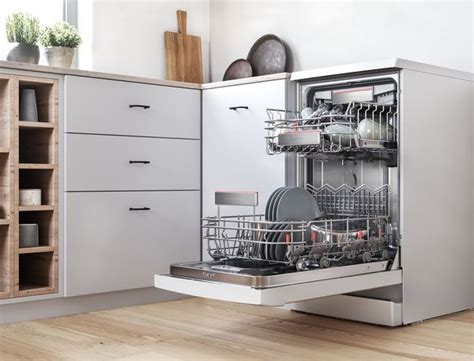 Freestanding slimline dishwasher with an open door in a stylish kitchen.