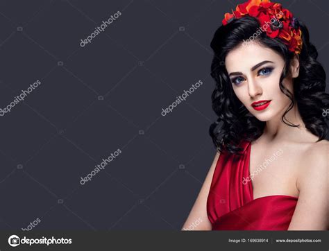 Young girl with red flowers in hair — Stock Photo © DemidenkoElena #169638914