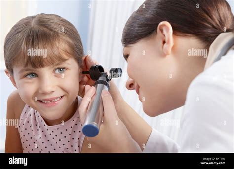 Ear examination. Otoscope being used by a general practice doctor to ...