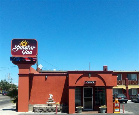 a red building with a fountain in front of it and a sign that says sun star inn