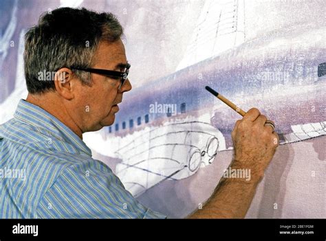 Close up of an aviation artist as he paints a mural picture of in-flight aircraft at the jet ...