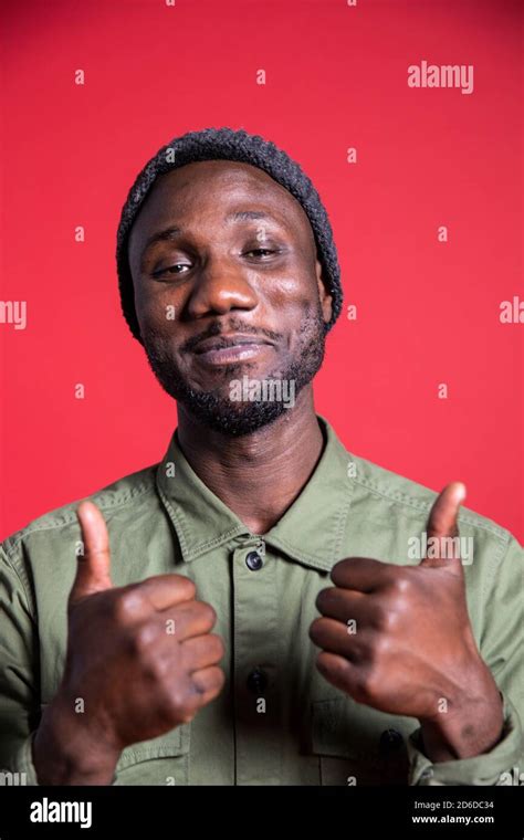 Young black man with closed mouth smile giving two thumbs up. Isolated ...