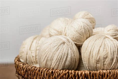 Close up view of yarn balls in wicker basket on grey background - Stock ...