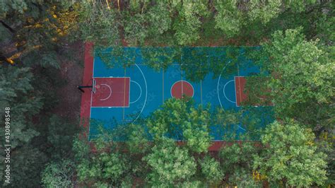 Aerial view of basketball court hidden by trees in a park. field proper ...