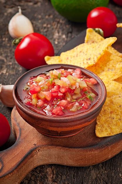 Mexican nacho chips and salsa dip in bowl on wooden | Free Photo