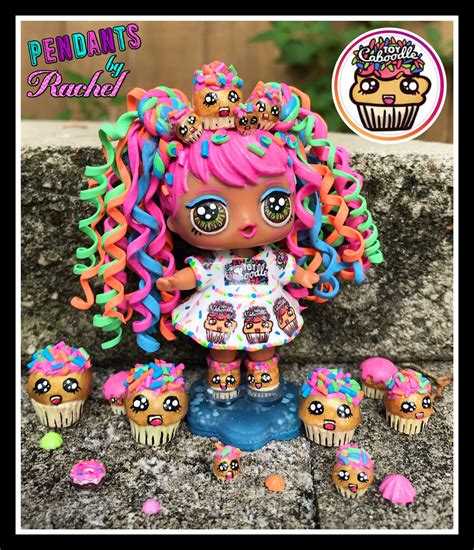 a doll with pink hair is standing next to cupcakes