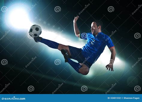 Soccer Player In Mid Air Kicking The Soccer Ball, Stadium Lights At Night In Background Stock ...