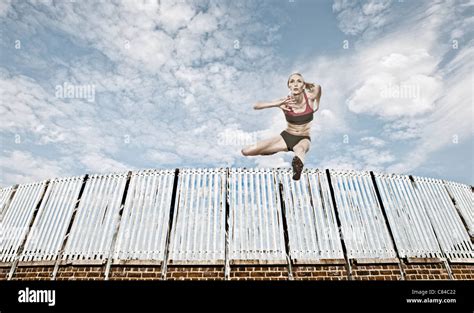 Athlete jumping over fence Stock Photo - Alamy