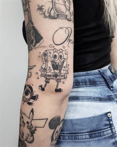 a woman's arm with tattoos on it and an image of spongebob