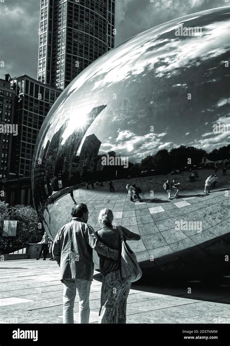 A Couple Stare at Their Reflections in Cloud Gate, Chicago Stock Photo ...