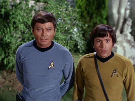 two men standing next to each other wearing star trek uniforms