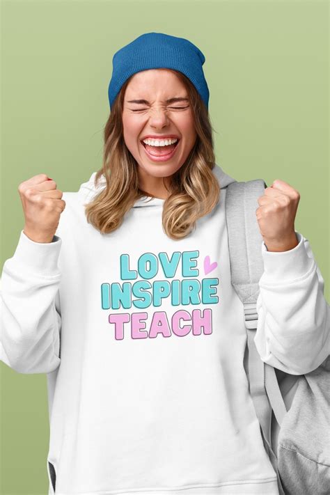a woman wearing a white sweatshirt with the words love inspire teach on it and smiling